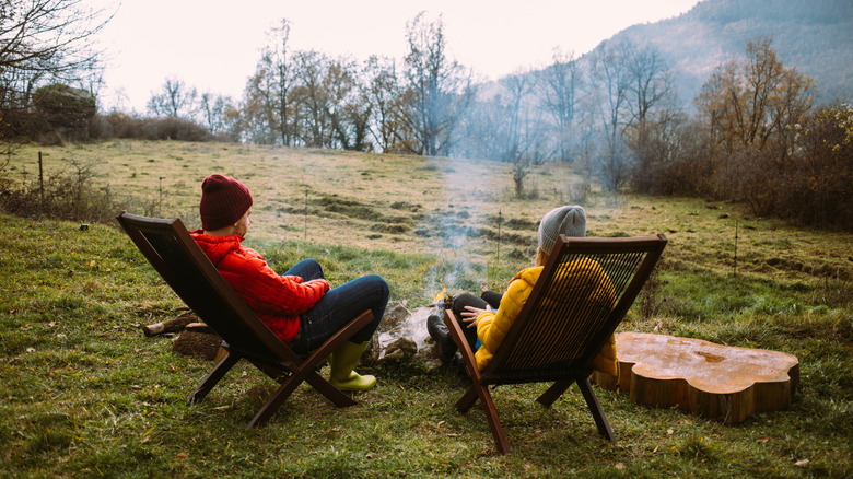 Couple sitting outside by a fire