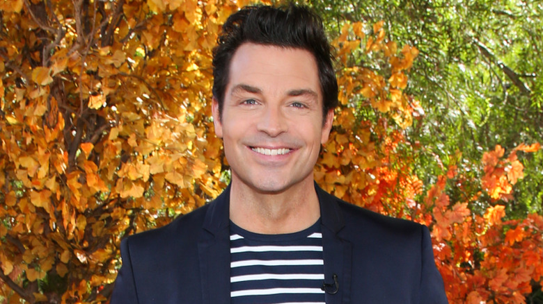Brennan Elliott smiling in front of fall leaves