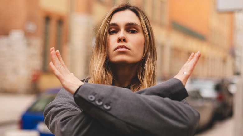 Woman with her arms crossed with the bias symbol