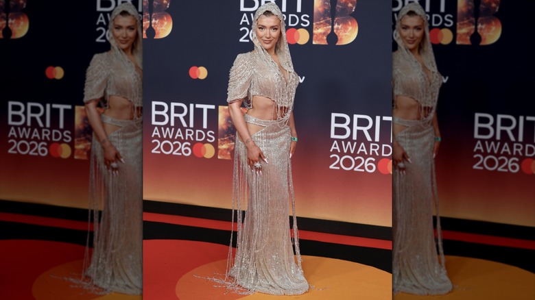 Molly Marsh posing in a semi-sheer dress with silver beading, cutouts, and a hood.