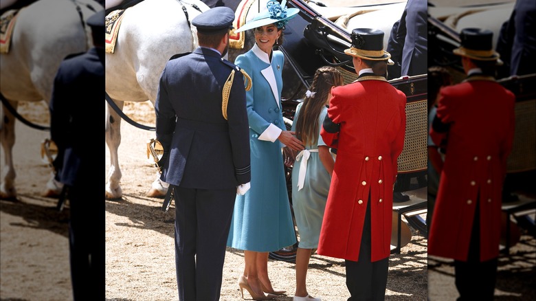 Princess Kate in turquoise coat dress getting in carriage with Princess Charlotte