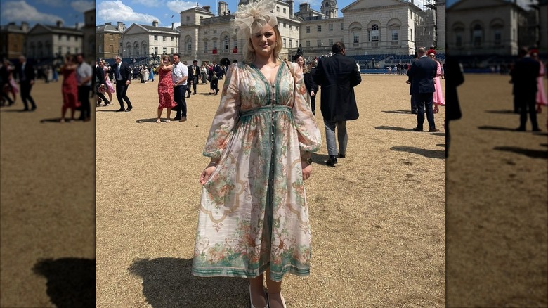Alex Davies-Jones at Trooping the Color, standing in gravel courtyard, wearing a billowy patterned dress