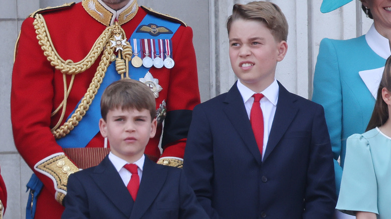 Prince Louis and Prince George on balcony at Trooping the Colour, wearing same dark blue suits and red ties