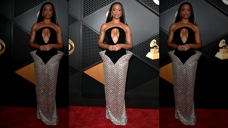 Ari Lennox posing in a gown with structured silver skirt and a black bodice with a large cutout