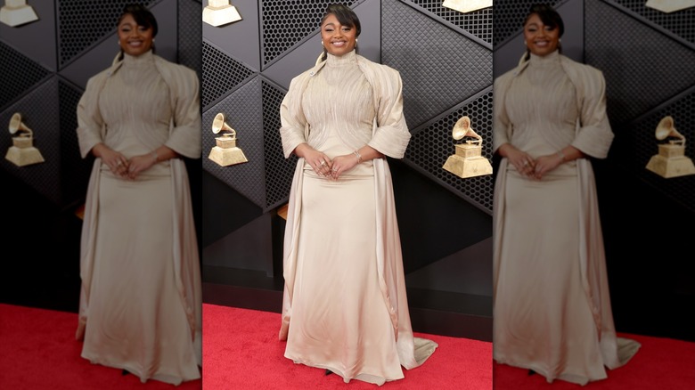 Samara Joy smiling in a beige floor-length gown with mock neck
