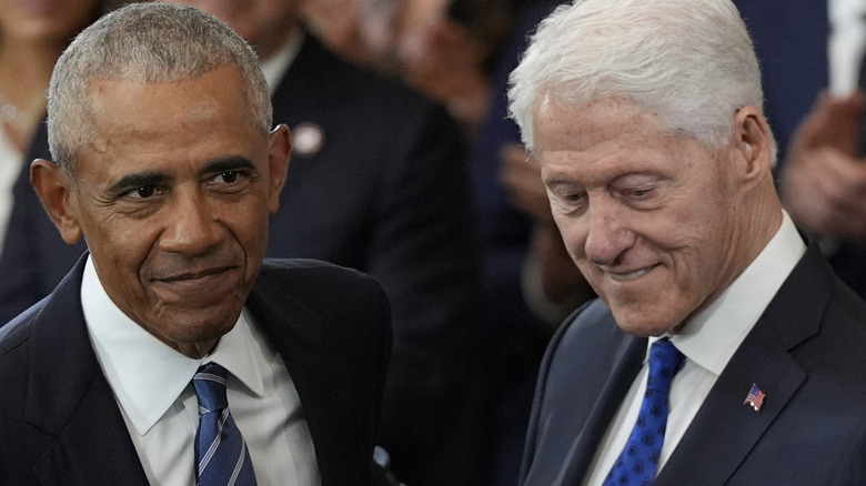 Barack Obama and Bill Clinton standing next to each other