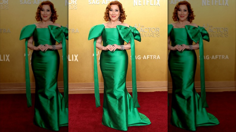 Lisa Ann Walter posing in a green gown with bows on the shoulders at the 2026 Actor Awards
