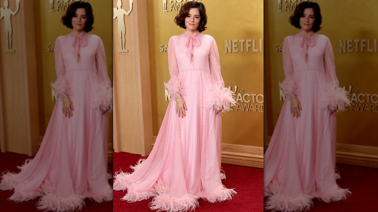 Parker Posey posing in a pink marabou dress at the 2026 Actor Awards
