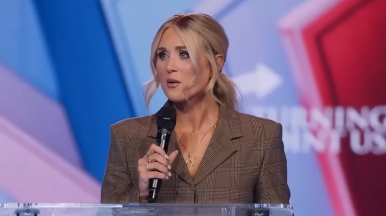 Riley Gaines brown suit AmericaFest 2025