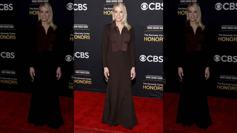 Pam Bondi standing on the red carpet at the Kennedy Center Honors in a brown dress.