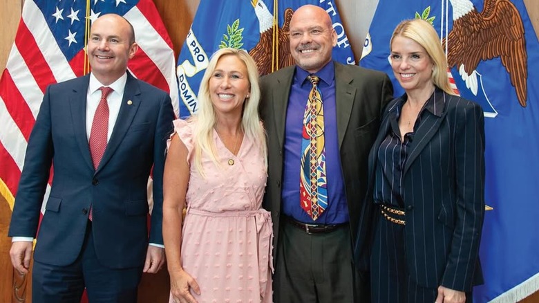 Pam Bondi in a pinstripe suit with Marjorie Taylor-Greene, Mike Lee, and Kirk Moore.