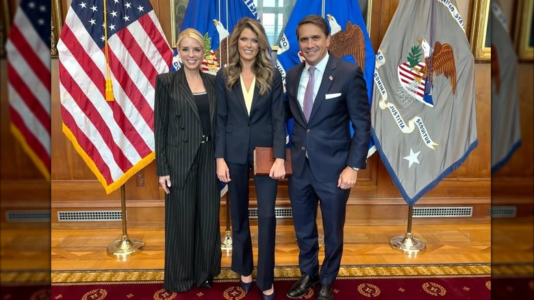 Pam Bondi in an oversized suit with Lindsey Halligan and Todd Blanche.