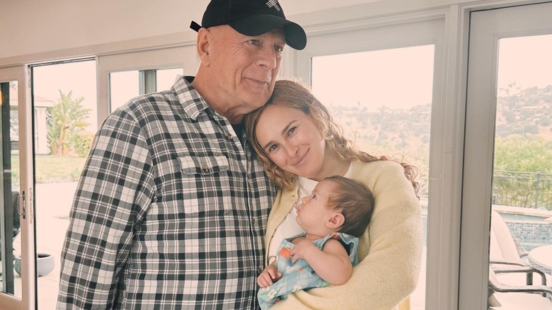 Bruce Willis hugs Rumer Willis, holding baby Louetta Thomas Willis