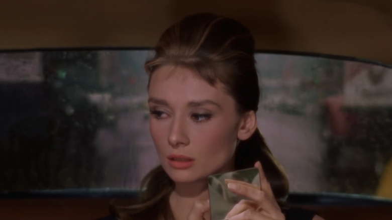 Audrey Hepburn applying lipstick 