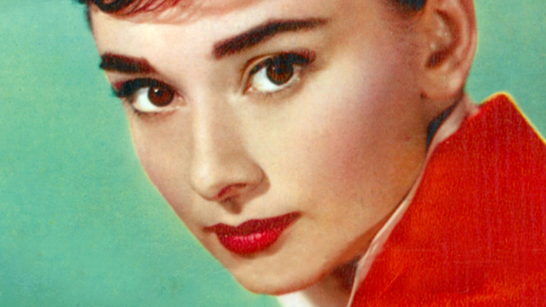Audrey Hepburn wearing red lipstick and a pixie haircut