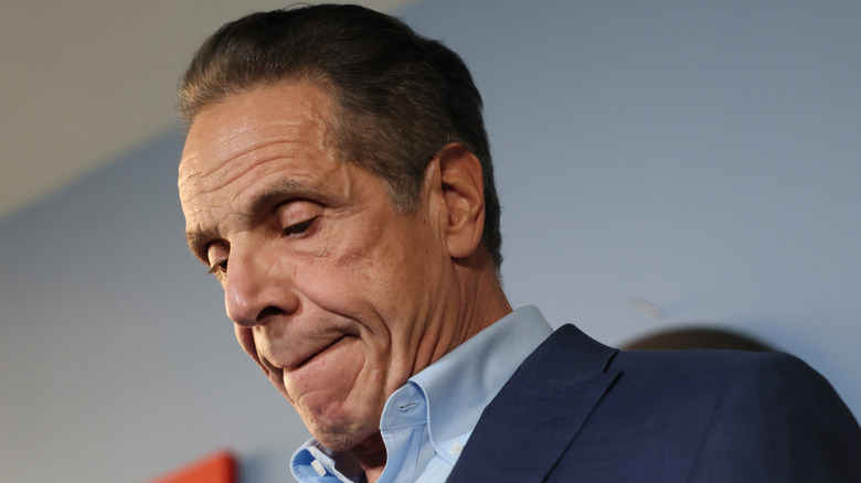 Andrew Cuomo chewing on his lip and looking down.