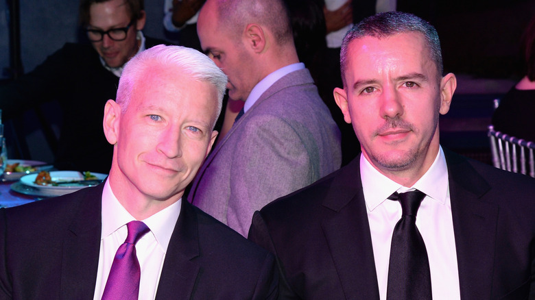 Anderson Cooper and Benjamin Maisani posing for photos at an event in dark suits