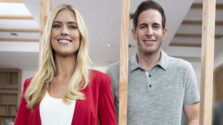 Christina Hall and Tarek El Moussa stand by house framing