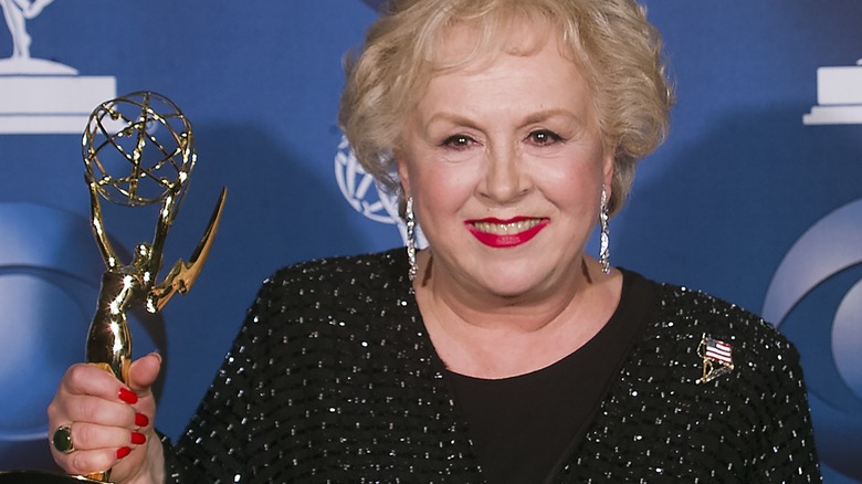 Doris Roberts holding up an Emmy