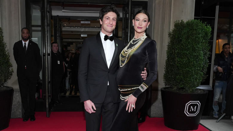 A pregnant Karlie Kloss and her husband Joshua Kushner posing for a photo