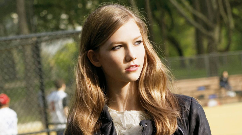 A young Karlie Kloss posing for a modeling shoot in an outdoor setting