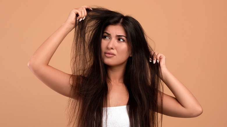 Woman checking frizzy hair