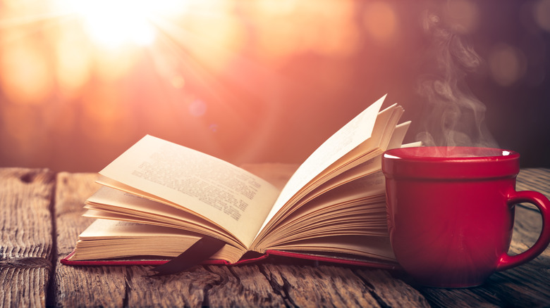 coffee and journal in front of water 