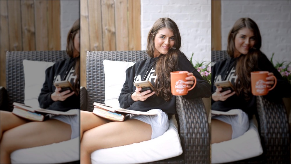 Madison Prewett posing with a cup of coffee outside