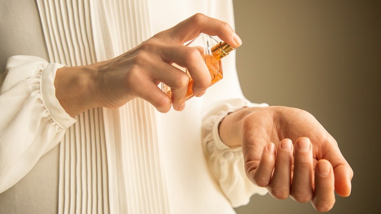 Woman spraying perfume