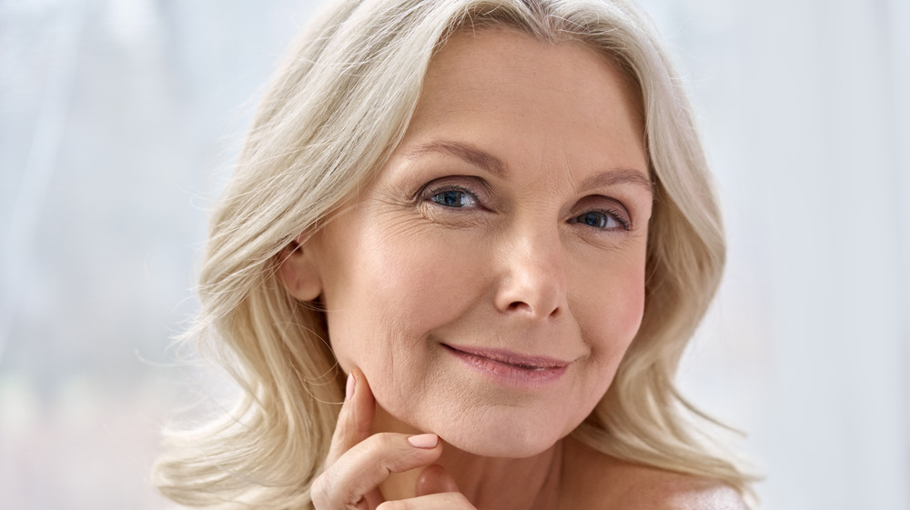 Woman smiling and touching face