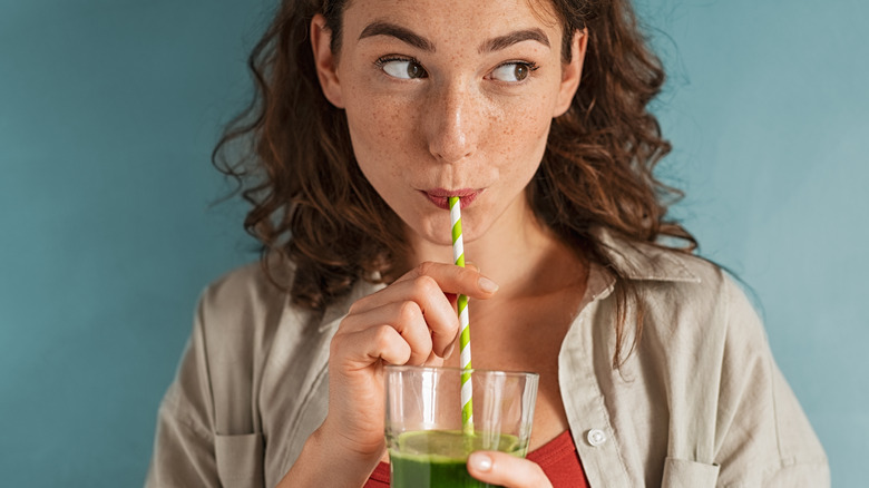 Woman drinking a green smoothie