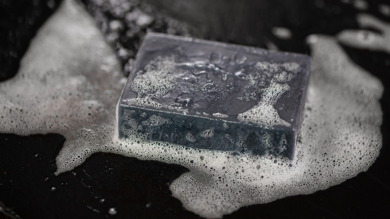 Bar of black soap with suds