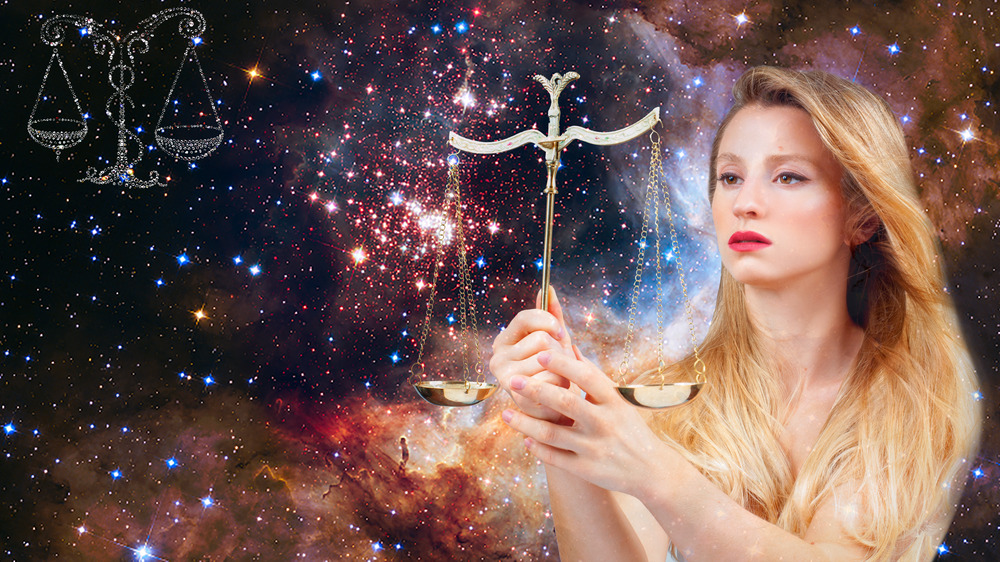 Woman holding Libra scales in starry sky