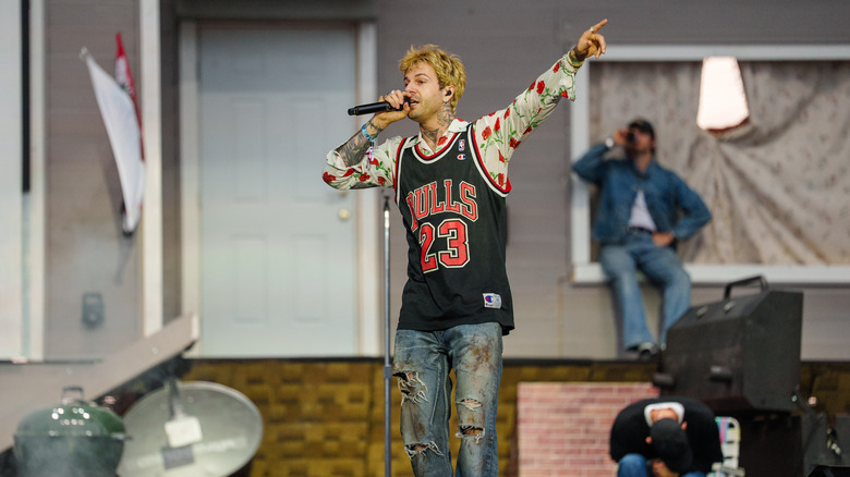 Jesse Rutherford of The Neighborhood performing in a rose printed button up under a Bulls jersey with ripped dirty jeans