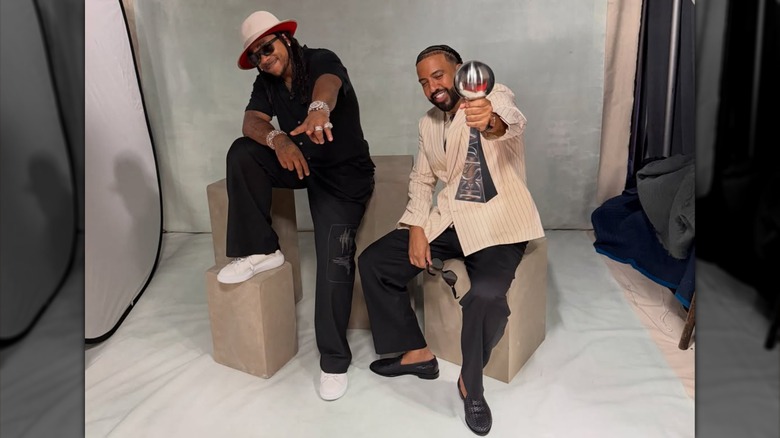 French Montana holding his ESPY Award toward the camera with Max B by his side