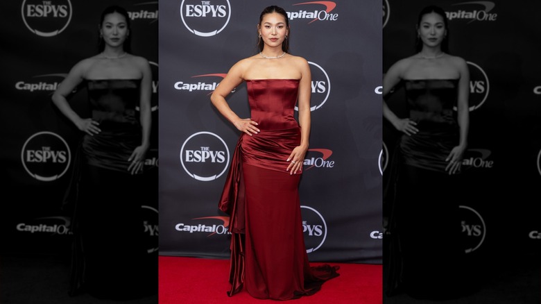 Chloe Kim with a hand on her hip in a red dress on the ESPYS red carpet in 2026
