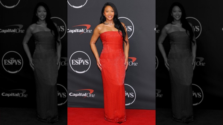 Sunisa Lee with her hands by her side in a red dress on the ESPYS red carpet in 2026, smiling