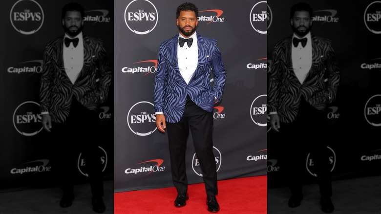 Russell Wilson in a zebra print suit jacket with a hand in his pocket on the ESPYs red carpet in 2026