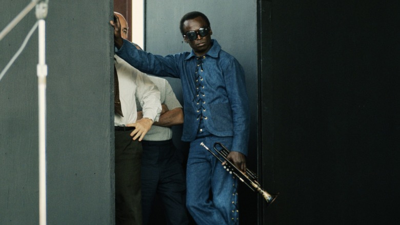 Miles Davis leaning against a wall backstage at the Newport Jazz Festival in 1969.