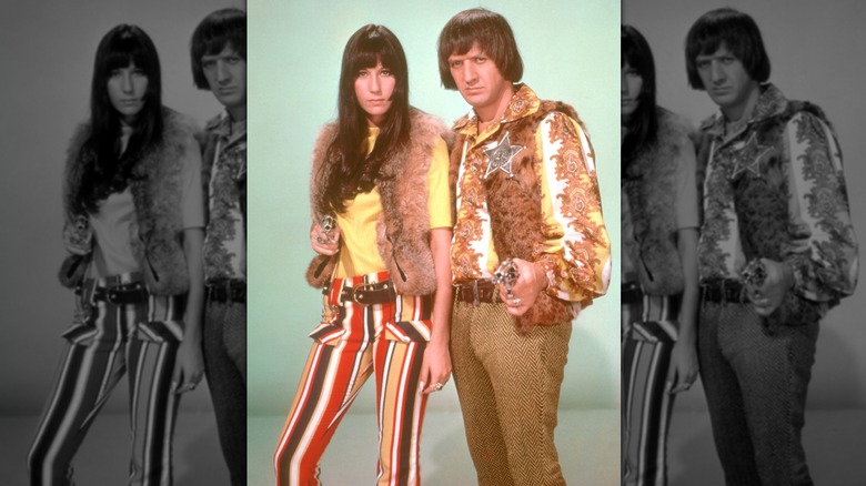 Sonny and Cher pointing toy guns at the camera, both wearing fur vests.