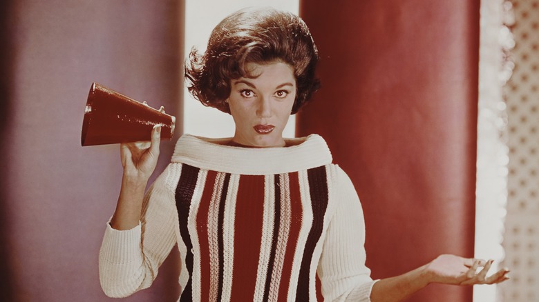 Connie Francis shrugging in a striped sweater and holding a megaphone.