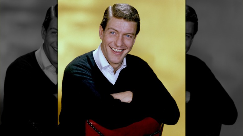 Dick Van Dyke smiling in a shirt and V-neck sweater in the 1960s.