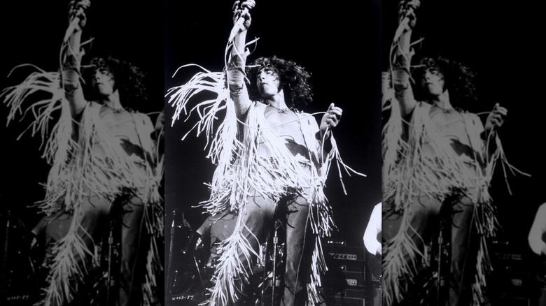 Roger Daltrey performing at Woodstock in 1969 in a tasseled outfit.
