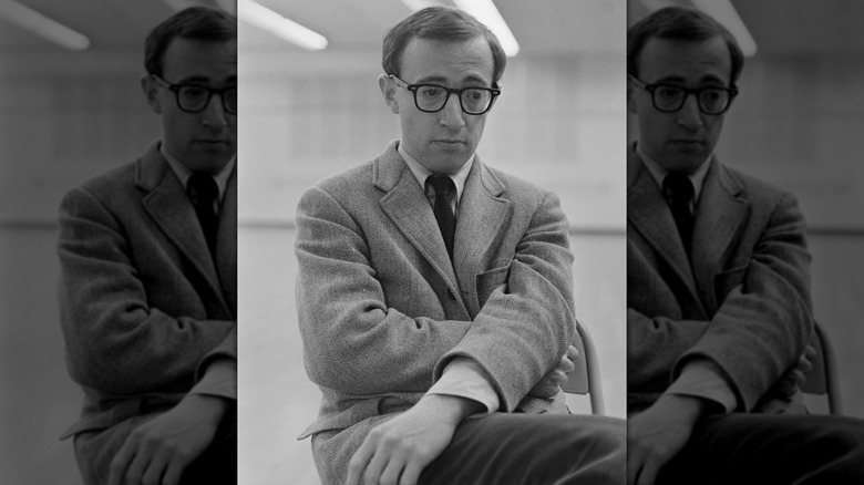 A black and white portrait of Woody Allen wearing a suit.