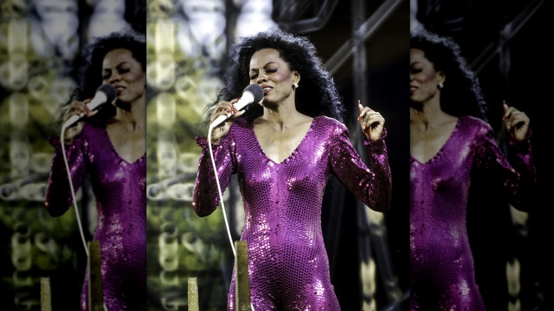 Diana Ross (wearing a sequin purple bodysuit) while performing at a concert in 1983.