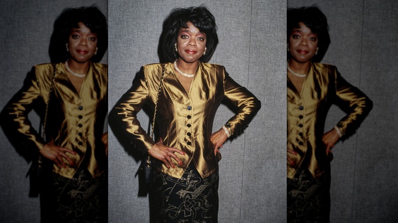 Oprah Winfrey attending an event in 1989, wearing a gold shirt and black skirt.