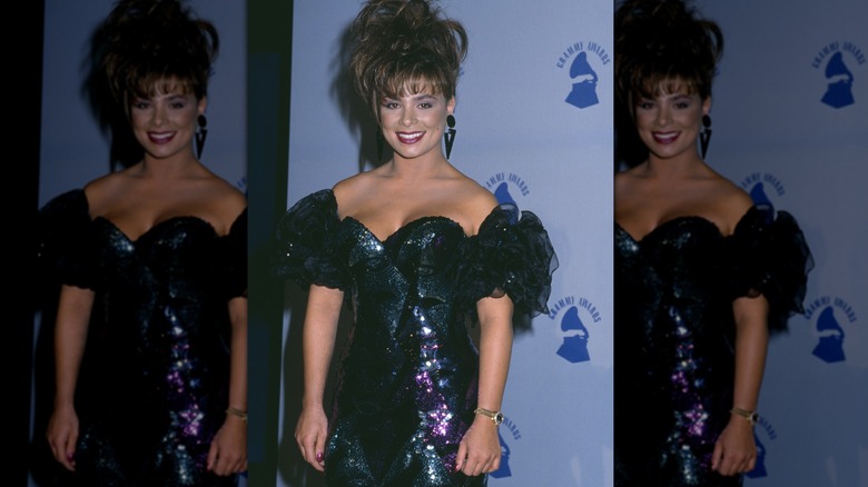 Paula Abdul smiling in a dark blue dress at the 31st Grammy Awards in 1989.