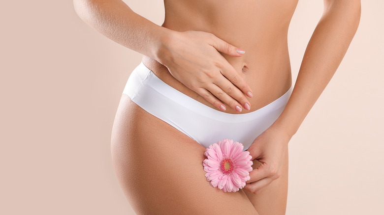 Woman in underwear holding flower