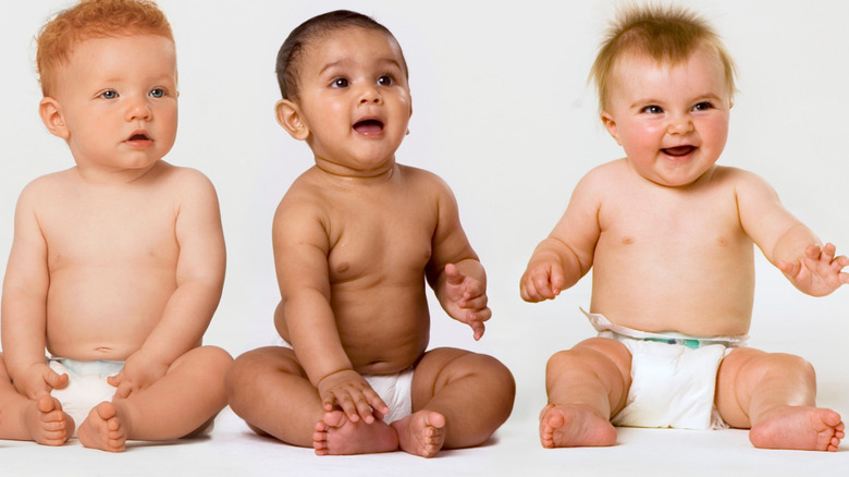 Babies sitting, smiling at camera