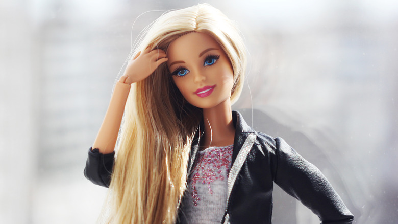 Barbie doll with hand going through hair